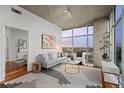 Well-lit living room with hardwood floors, floor-to-ceiling windows, and a view of the city skyline at 1700 Bassett St # 1612, Denver, CO 80202