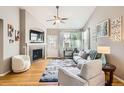 Bright living room with vaulted ceilings, fireplace, hardwood floors, and large windows at 11332 E 111Th Ave, Commerce City, CO 80640