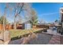Well-maintained backyard with a storage shed, patio furniture, and a fenced perimeter at 9731 W Polk Dr, Littleton, CO 80123