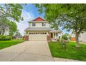 Inviting two-story home with a well-kept lawn and driveway leading to an attached two-car garage at 5023 Goshawk Ct, Brighton, CO 80601
