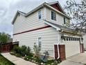 Inviting two-story home featuring an attached two-car garage, well-kept flower beds, and neutral-colored siding at 5023 Goshawk Ct, Brighton, CO 80601