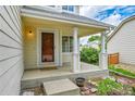 Inviting covered porch with white columns and a warm, welcoming entrance at 5023 Goshawk Ct, Brighton, CO 80601