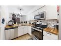 Bright kitchen features butcher block counters, stainless steel appliances, and white cabinetry at 1242 S Crystal Way, Aurora, CO 80012