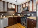 A contemporary kitchen boasts wood cabinets, stainless steel appliances, and stone countertops at 740 N Sherman St # 208, Denver, CO 80203