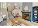 Bright living room featuring a fireplace with decorative tile, and stairs with modern railings to the second level at 11358 W 85Th Pl # E, Arvada, CO 80005