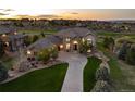 Beautiful home at sunset features manicured lawns and mature trees with a large driveway at 5409 Sedona Dr, Parker, CO 80134