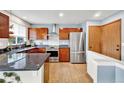 Well-equipped kitchen with stainless steel appliances, granite countertops, and wood cabinetry at 14430 W Yale Pl, Lakewood, CO 80228
