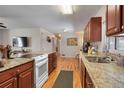 Well-equipped kitchen featuring wood cabinetry, granite counters, and modern appliances at 3423 S Glencoe St, Denver, CO 80222