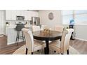 Open concept dining area with hardwood floors, a round table, and seating for four at 6393 N Malaya St, Aurora, CO 80019