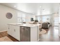 Modern kitchen with stainless steel appliances, island, and open floor plan into the living area at 6393 N Malaya St, Aurora, CO 80019