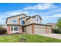 Traditional two-story home with lush lawn, mature landscaping, and a convenient three-car garage at 133 Heritage Ave, Castle Rock, CO 80104