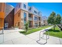 Contemporary townhome boasts brick accents, a manicured lawn, and convenient sidewalk access, exuding urban charm at 2550 Lawrence St # 106, Denver, CO 80205