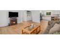 Bright living room with wood floors, a decorative fireplace, and a view into the kitchen and laundry room at 1641 Biscay Cir, Aurora, CO 80011