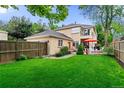 Spacious backyard featuring a lush green lawn, privacy fence, and a detached garage at 2411 S Milwaukee St, Denver, CO 80210