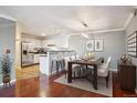 Open dining area with a table set for six, a view into the kitchen, and wood floors at 12338 W Dorado Pl # 206, Littleton, CO 80127