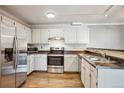 Functional kitchen featuring white cabinets, stainless steel appliances, and a double sink at 12338 W Dorado Pl # 206, Littleton, CO 80127