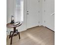 Bright entryway featuring wood floors, white trim, and a stylish side table with a lamp at 16347 E 111Th Dr, Commerce City, CO 80022