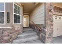 Close up of front door with brick detail and a side-entry garage at 23590 E Jamison Pl, Aurora, CO 80016