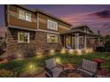 Inviting backyard patio features a covered porch with outdoor seating and a fire pit area for entertaining at 7004 S Addison Ct, Aurora, CO 80016
