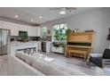 Bright, open living room featuring a piano, stainless steel appliances, and neutral color palette at 1310 Hoyt St # 6, Lakewood, CO 80215