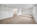 Bright living room with neutral carpeting, white walls, and a spacious layout at 14190 E Gunnison Pl, Aurora, CO 80012