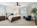 Bright main bedroom with large windows, ceiling fan, and a comfortable seating area at 42973 Colonial Trl, Elizabeth, CO 80107