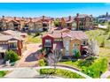 Stunning aerial view of homes with red roofs, lush green lawns, and meticulously landscaped yards in a planned community at 9588 Firenze Way, Highlands Ranch, CO 80126