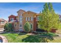 Elegant home boasting a stone facade, large windows, manicured lawn, and mature trees, offering curb appeal at 9588 Firenze Way, Highlands Ranch, CO 80126