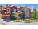 Charming two-story home with a combination of brick and stucco exterior, a well-manicured lawn and mature trees at 9588 Firenze Way, Highlands Ranch, CO 80126