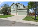 Two story home with a green exterior, 2 car garage and a concrete driveway at 22 Apache Plume St, Brighton, CO 80601