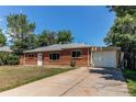 Ranch style red brick home featuring a well-kept lawn and attached garage at 9150 Lilly Ct, Thornton, CO 80229
