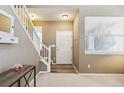 Bright and inviting foyer with a staircase, a front door, and neutral decor at 9378 Longstone Dr, Parker, CO 80134