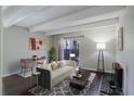 Cozy living room with beamed ceiling, dining area, and sliding glass doors to outdoor patio at 9995 E Harvard Ave # 155, Denver, CO 80231