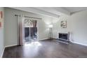 Bright living room featuring beamed ceiling, fireplace, and sliding glass doors to the patio at 9995 E Harvard Ave # 155, Denver, CO 80231