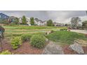 Expansive backyard with a lush lawn, mature trees, and a charming wooden fence. Includes a concrete patio with seating at 5394 S Valdai Way, Aurora, CO 80015