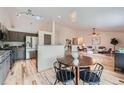 Open-concept living space with light wood floors, a modern kitchen, and a cozy seating area at 5394 S Valdai Way, Aurora, CO 80015