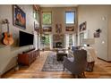 Living room boasting a stone fireplace, soaring ceilings, and large windows at 27756 Troublesome Gulch Rd, Evergreen, CO 80439