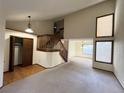 Bright, open living area with high ceilings, staircase, carpet and large windows allowing for natural light at 17969 E Brown Pl, Aurora, CO 80013