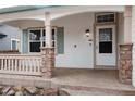 Covered front porch with stone pillars and stamped concrete, providing curb appeal at 9450 Troon Village Dr, Lone Tree, CO 80124