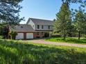 Charming two-story home with a three-car garage and a beautiful, sprawling lawn at 11824 E Basswood Ln, Franktown, CO 80116