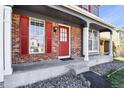 Inviting front porch showcasing brickwork, white columns, and a vibrant red front door at 19828 E Brown Pl, Aurora, CO 80013