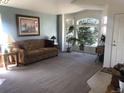 Bright living room features large bay windows, neutral carpet, and a cozy seating area at 1998 E 100Th Pl, Thornton, CO 80229