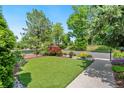 Manicured front yard with artificial turf, attractive landscaping, and an ornamental fence creating a welcoming outdoor space at 1551 S Grant St, Denver, CO 80210