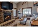 Cozy living room featuring a stone fireplace and a comfortable leather sofa at 107 Ski Watch Rd # 32, Breckenridge, CO 80424