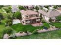 Large backyard features a sports court, covered patio, fire pit, in-ground trampoline, and a lush lawn at 16491 Fairway Dr, Commerce City, CO 80022