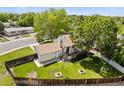 Aerial view of a house with a large fenced yard, mature trees, and a charming deck area at 11199 Dahlia Pl, Thornton, CO 80233