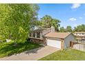 Aerial view of a charming two-story home with a spacious driveway and fenced backyard at 11199 Dahlia Pl, Thornton, CO 80233
