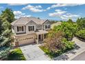 Two-story home features a well manicured front yard with mature trees and a neutral color scheme at 3411 Springbriar Dr, Castle Rock, CO 80109