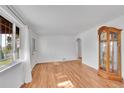 Bright living room featuring hardwood floors, fresh paint, and a view into other rooms at 4940 Adams St, Denver, CO 80216