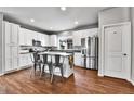 Bright, open kitchen with island seating, stainless steel appliances, and wood flooring at 11250 Florence St # 21A, Commerce City, CO 80640